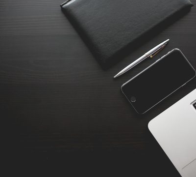 打屁股网站创始人张伟的工作照，他站在公司靛蓝色品牌墙前，面带自信微笑，展现出创业者的坚定与从容